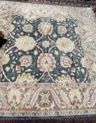 A blue ground rug with large flowerheads,