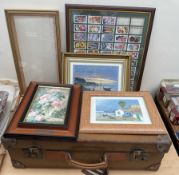 A leather suitcase together with framed cigarette cards,