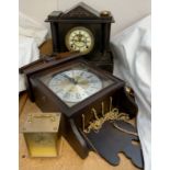 A black slate mantle clock together with a wall clock and a brass carriage clock
