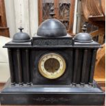 A black slate mantle clock with three domes above an architectural front and plinth base,