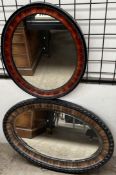 An oval wall mirror together with another oval wall mirror