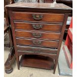 A mahogany music cabinet with five drawers and a shelf on square legs