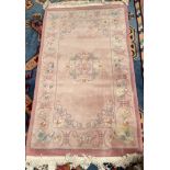 A pink ground Chinese rug, with flower heads and leaves,