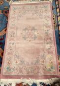 A pink ground Chinese rug, with flower heads and leaves,