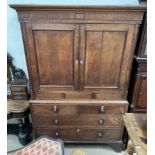 A 19th century oak linen press, with a moulded cornice above a pair of cupboard doors,