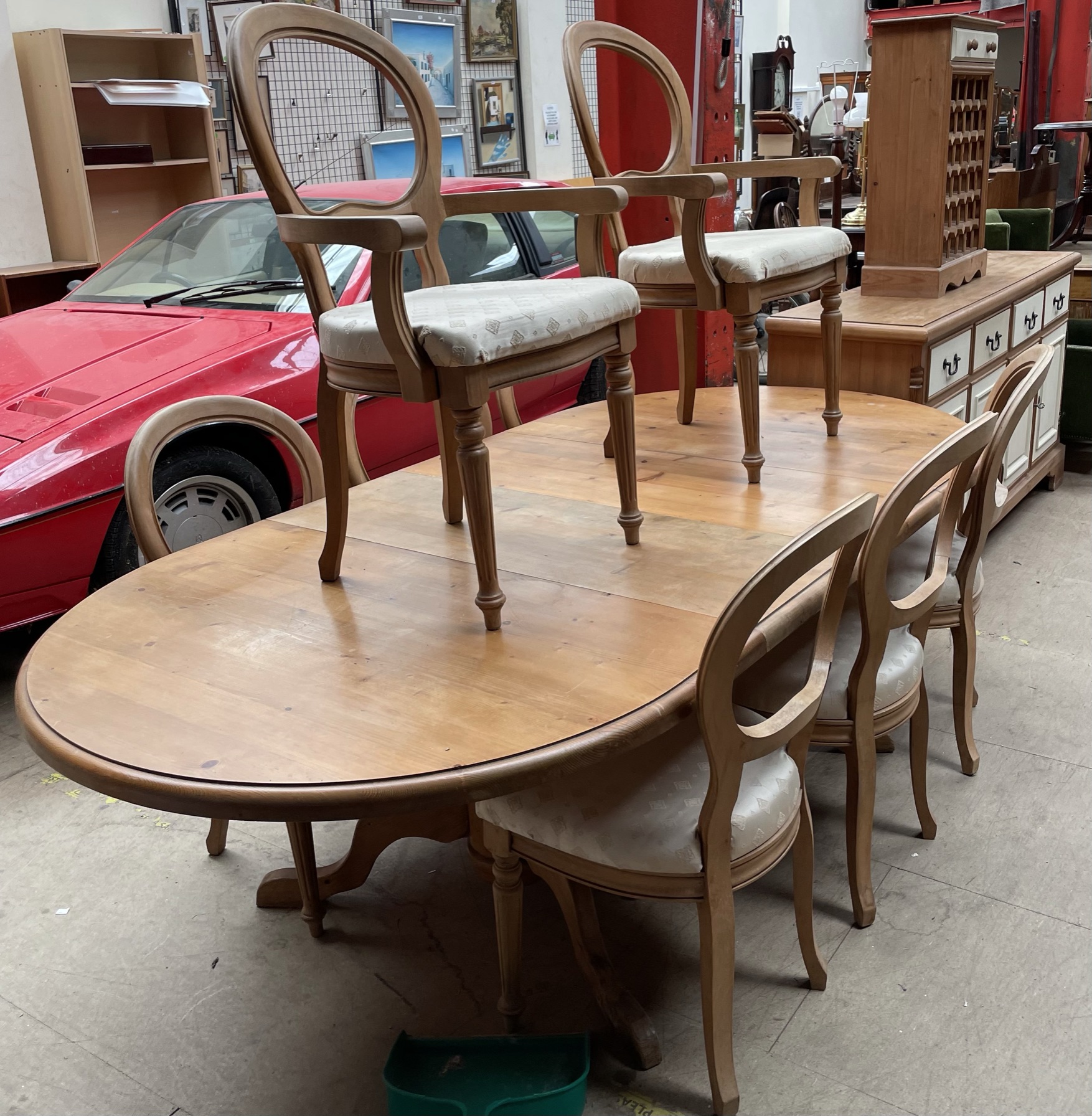 A modern pine extending dining table together with eight balloon back dining chairs a sideboard and