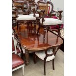 A reproduction mahogany dining suite comprising an extending dining table and ten chairs,