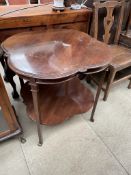 An Edwardian mahogany occasional table with a shaped top on square tapering legs united by an