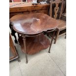 An Edwardian mahogany occasional table with a shaped top on square tapering legs united by an