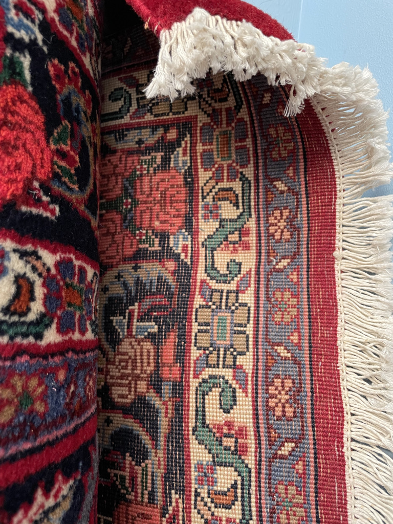 A red ground Persian rug, with interlaced flowers and leaves, the border decorated with roses, - Image 2 of 2