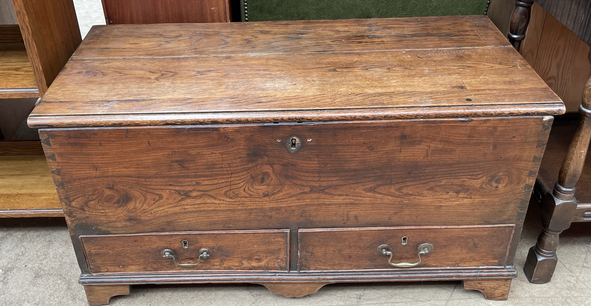 An 18th century coffer, with a planked top and two drawers on bracket feet,