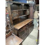 A 20th century oak dresser, the rack with carved door and shelves,