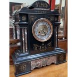 A black slate and marble mantle clock of architectural form, the silvered dial with Arabic numerals,