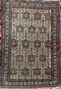 A Persian rug with a cream ground decorated with multiple vases of flowers 101 x 147cm