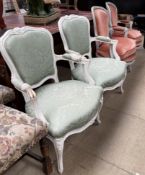 A pair of grey painted French elbow chairs together with a white painted pair