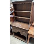 A 20th century oak dresser of small size, with a moulded cornice and two shelves,