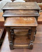 An oak nest of three rectangular topped tables on baluster tapering legs