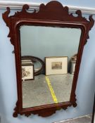 A George III style mahogany wall mirror with a scrolling top