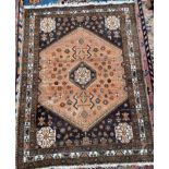 A Persian rug with an orange ground, decorated with flowerheads, birds and other animals,