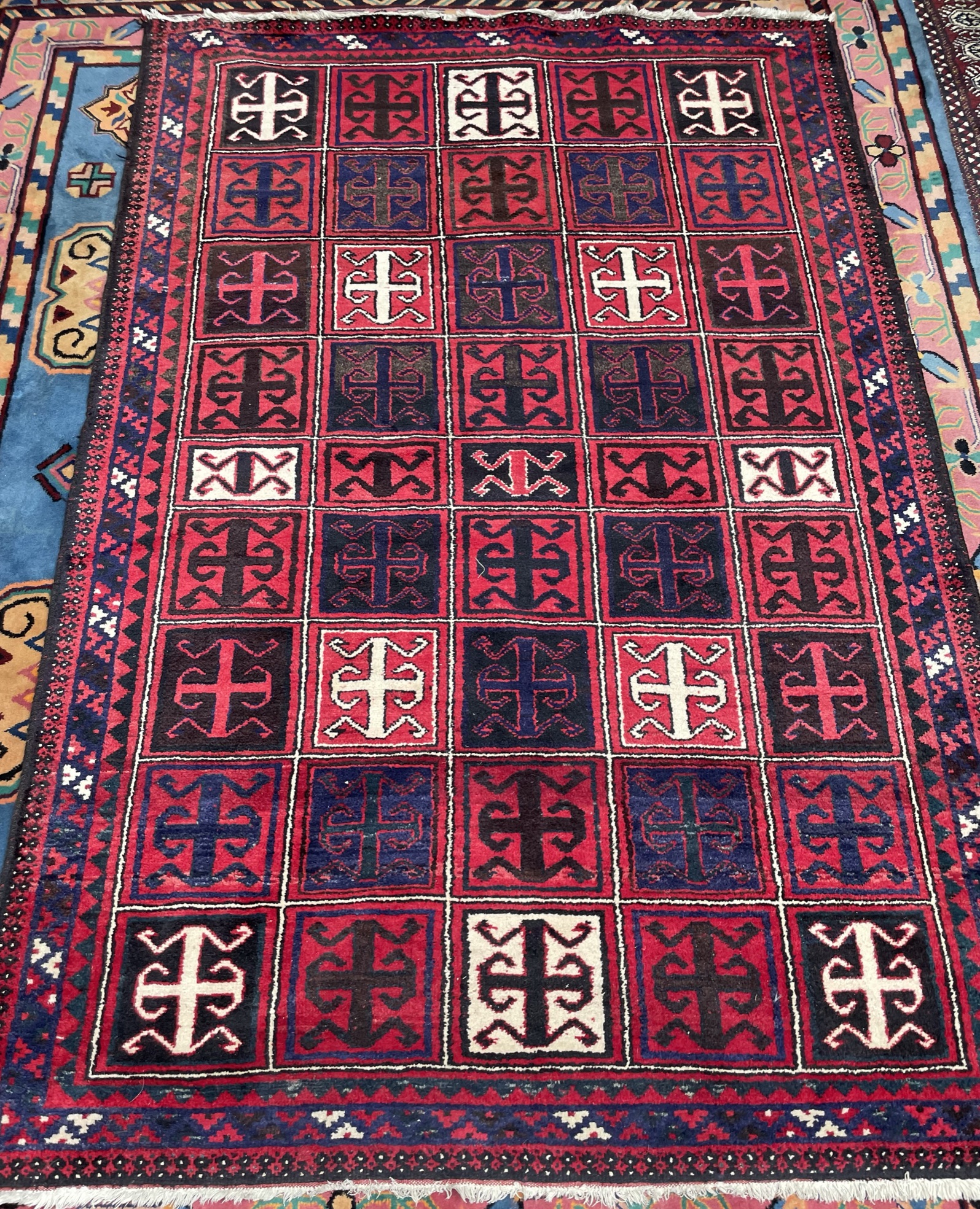 An Afghan rug, with a red ground and multiple medallions,