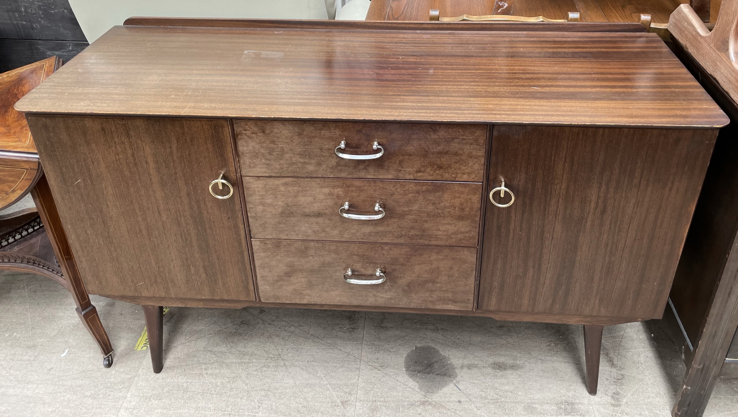 A mid 20th century dark teak sideboard, bears a trade label for Sutcliffe,