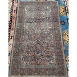 A blue ground Persian rug, profusely decorated with flowers and leaves,