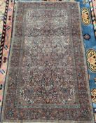 A blue ground Persian rug, profusely decorated with flowers and leaves,