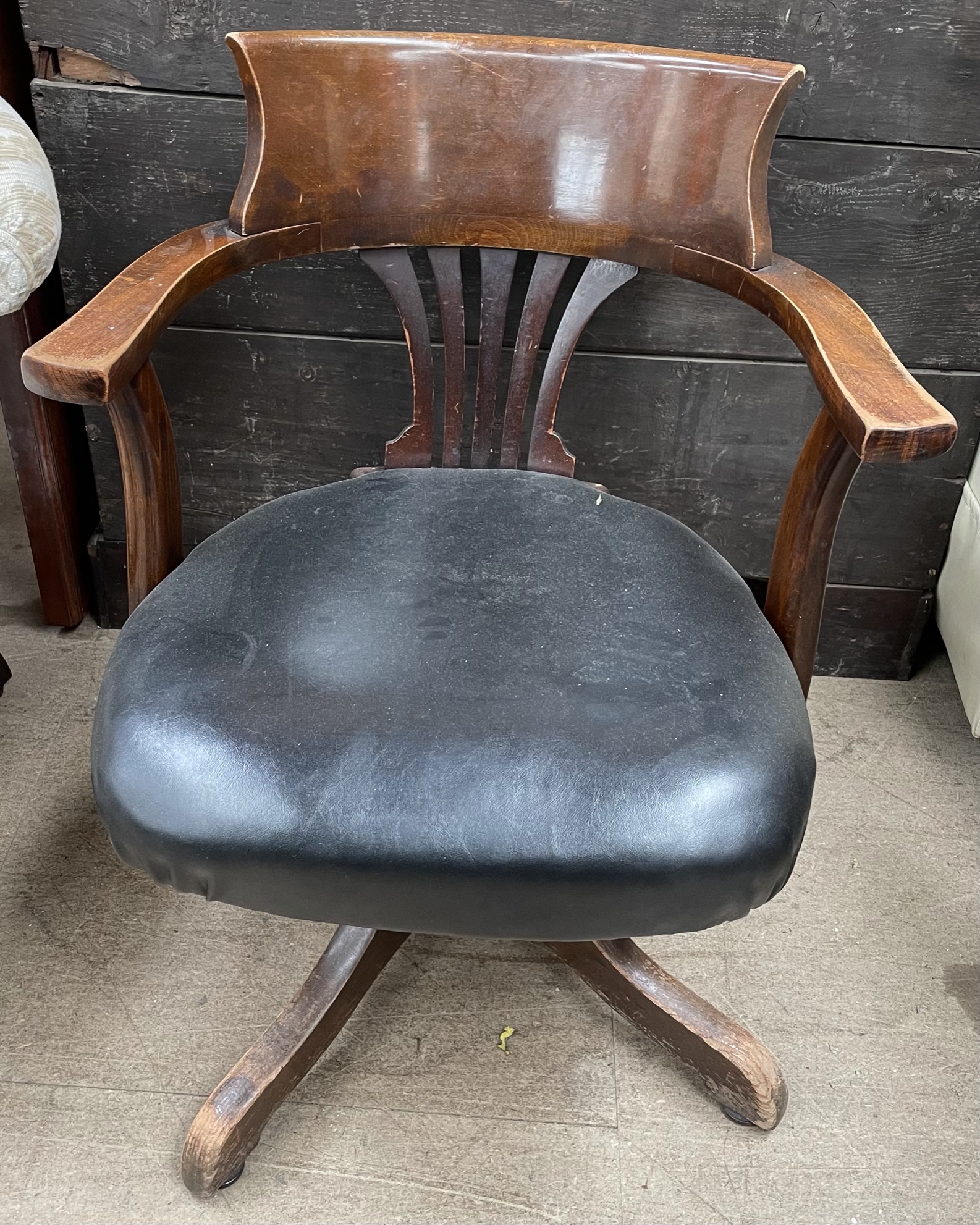 A 20th century upholstered captains chair with a pierced splat on a rotating base