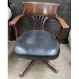 A 20th century upholstered captains chair with a pierced splat on a rotating base