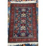 A persian rug, with a blue ground, with stylised flowerheads, to red guard stripes,