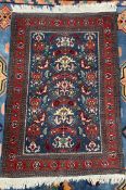 A persian rug, with a blue ground, with stylised flowerheads, to red guard stripes,