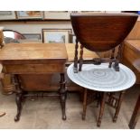 A Victorian walnut work / games table with a foldover top above a frieze drawer and well on turned