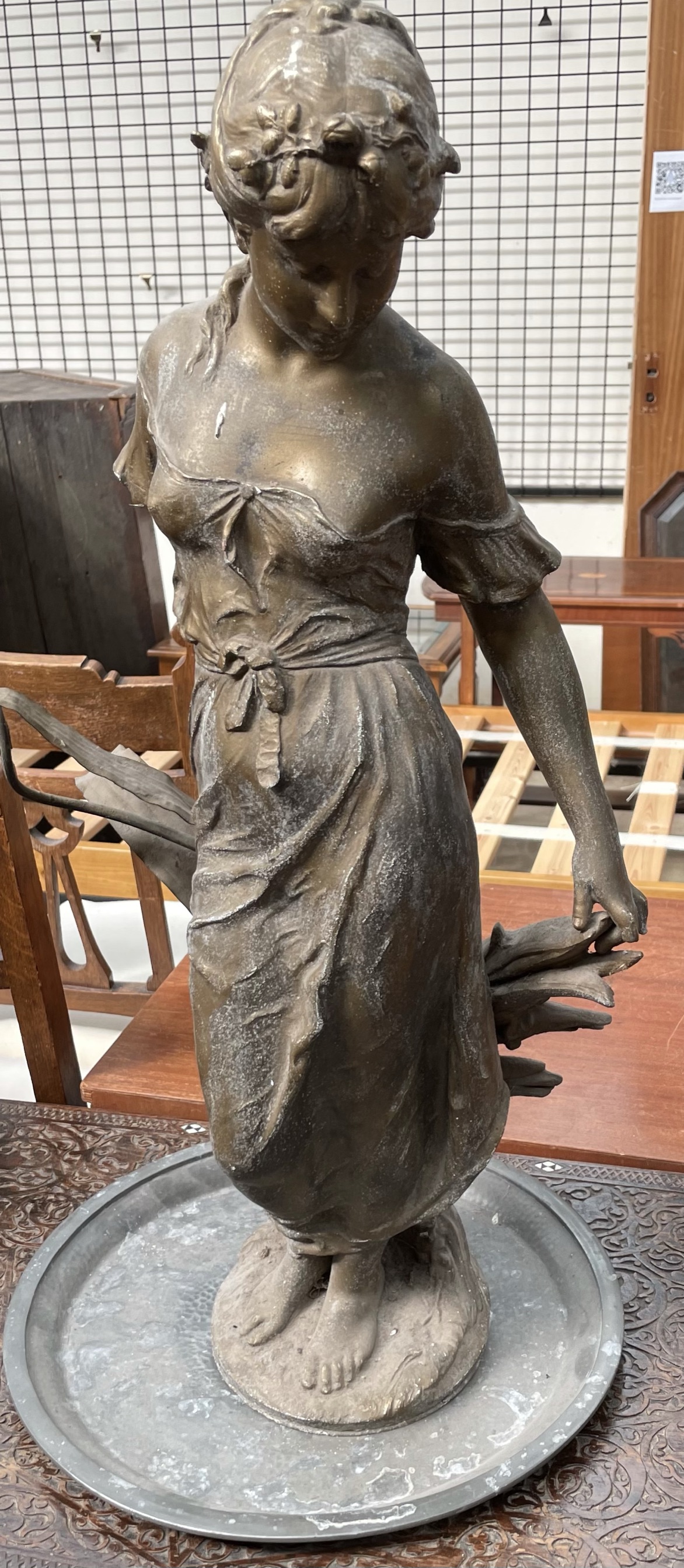 A gilt metal statute of a maiden