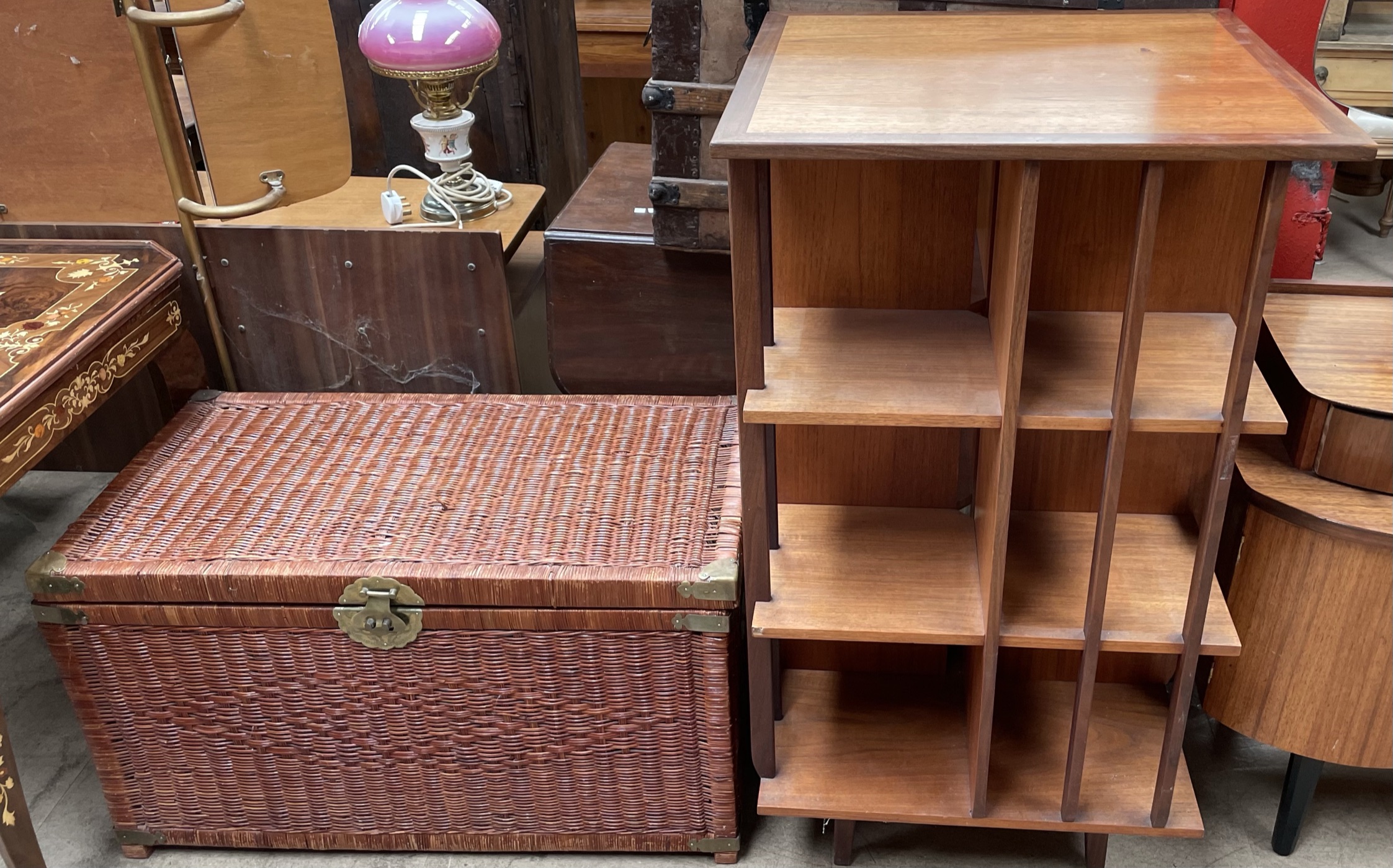 A teak revolving bookcase, with a square top above three shelves on a rotating base,