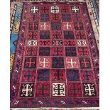 An Afghan rug, with a red ground and multiple medallions,