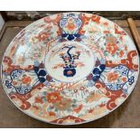 A large Japanese Imari charger decorated with a central vase of flowers