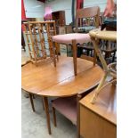 A mid 20th century teak dining suite, comprising a circular dining table with drop flaps,