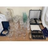 A glass decanter together with a cut glass claret jug, drinking glasses,