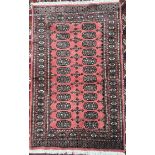 A pink ground Turkoman rug, with multiple guls and guard stripes.