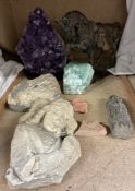 An amethyst geode together with other crystal samples, religious stone carving,