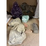 An amethyst geode together with other crystal samples, religious stone carving,