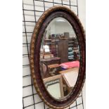 A gilt and painted oval wall mirror