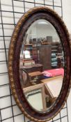 A gilt and painted oval wall mirror