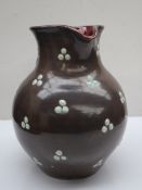 D Hallance - A studio pottery jug, with a mottled grey ground applied with green beads,