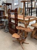 A glass top wine table with an elephant head base together with a mahogany shelf unit and a