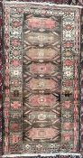 A pink ground rug, with eight geometric medallions and multiple guard stripes,