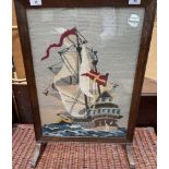 A 20th century oak framed fire screen with a woolwork of a ship