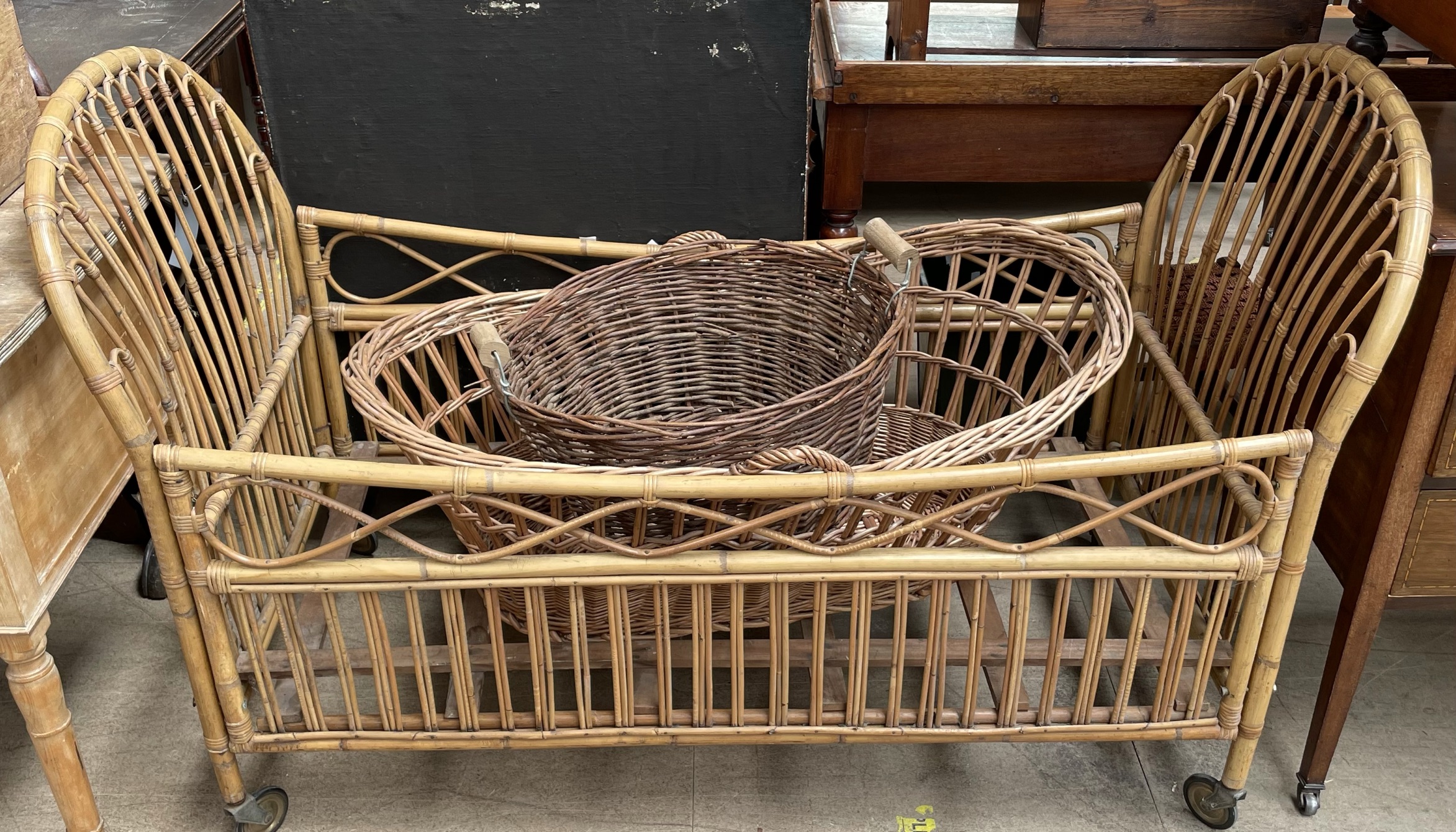 A bamboo child's cot together with a Moses basket and a twin handed basket