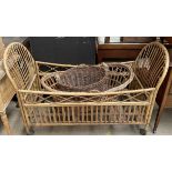 A bamboo child's cot together with a Moses basket and a twin handed basket