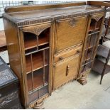 An oak bureau display cabinet, with a central pull down bureau drawer and cupboard,